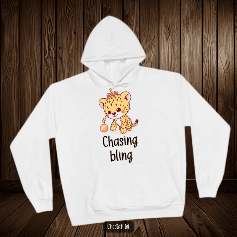 Funny cheetah cub hoodie showing a royal cub with a tiara, playfully chasing a toy, offering cozy and cute vibes.