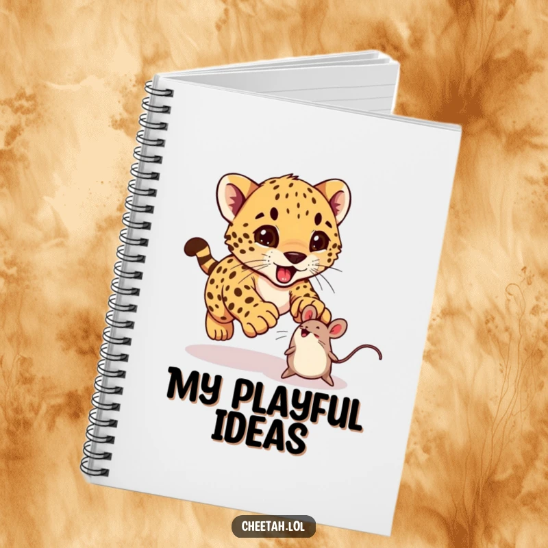 Funny cheetah cub excitedly pouncing on a bouncing toy mouse on a notebook, ideal for journaling.