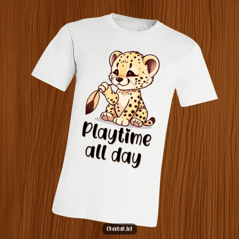 Funny cheetah cub t-shirt with a playful cub batting at a dangling feather, showing intense focus.