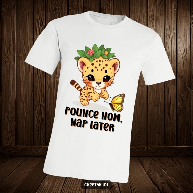 Funny t-shirt graphic of a cheetah cub wearing a leaf crown, mid-leap, playfully pouncing on a butterfly with a mischievous look.