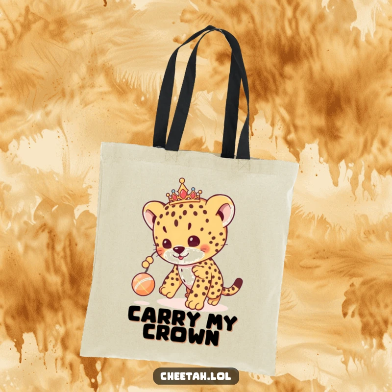 Funny cheetah cub tote bag featuring a regal cub with a tiara, playfully chasing a toy, perfect for carrying essentials with flair.